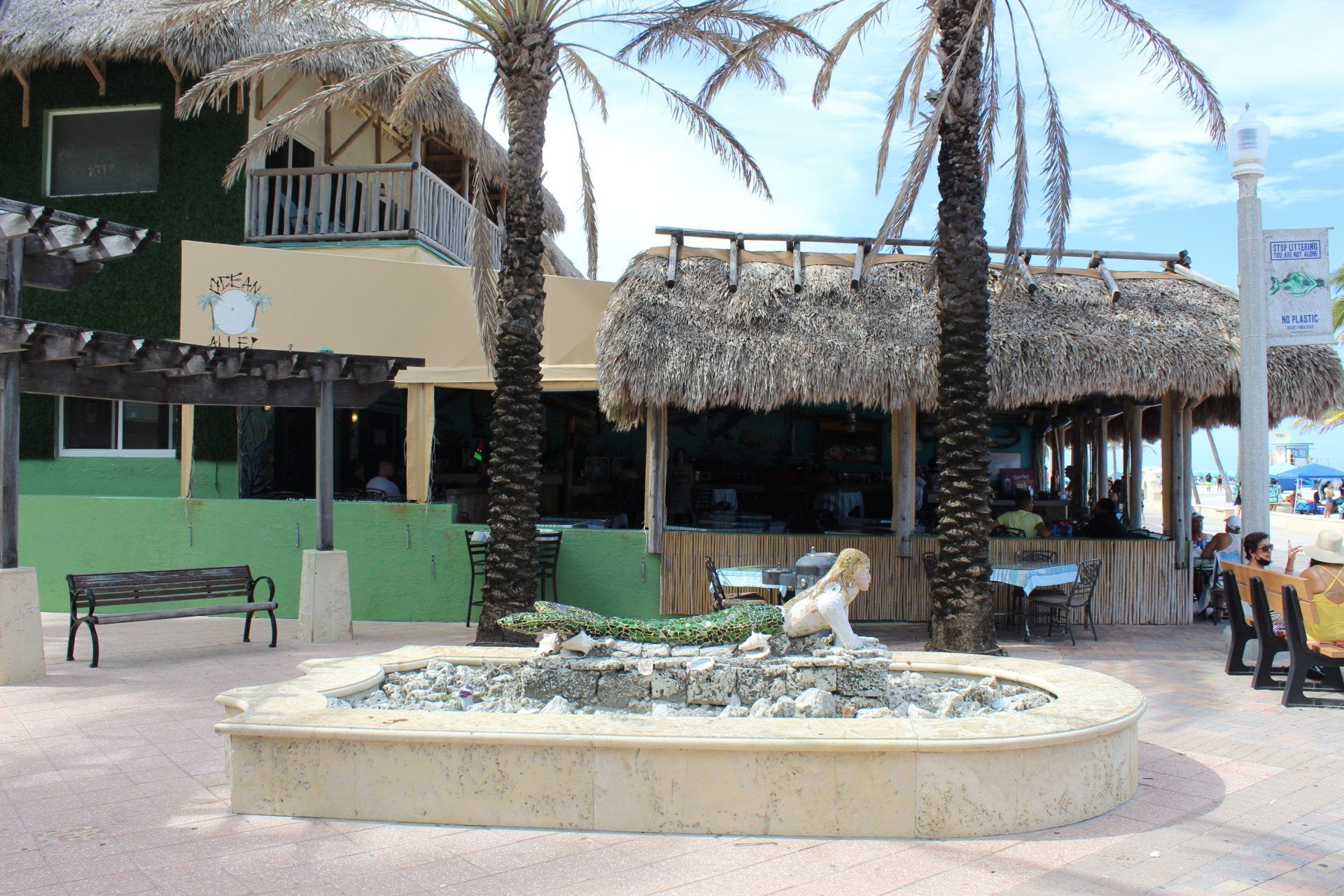 A fountain in front of a building with palm trees