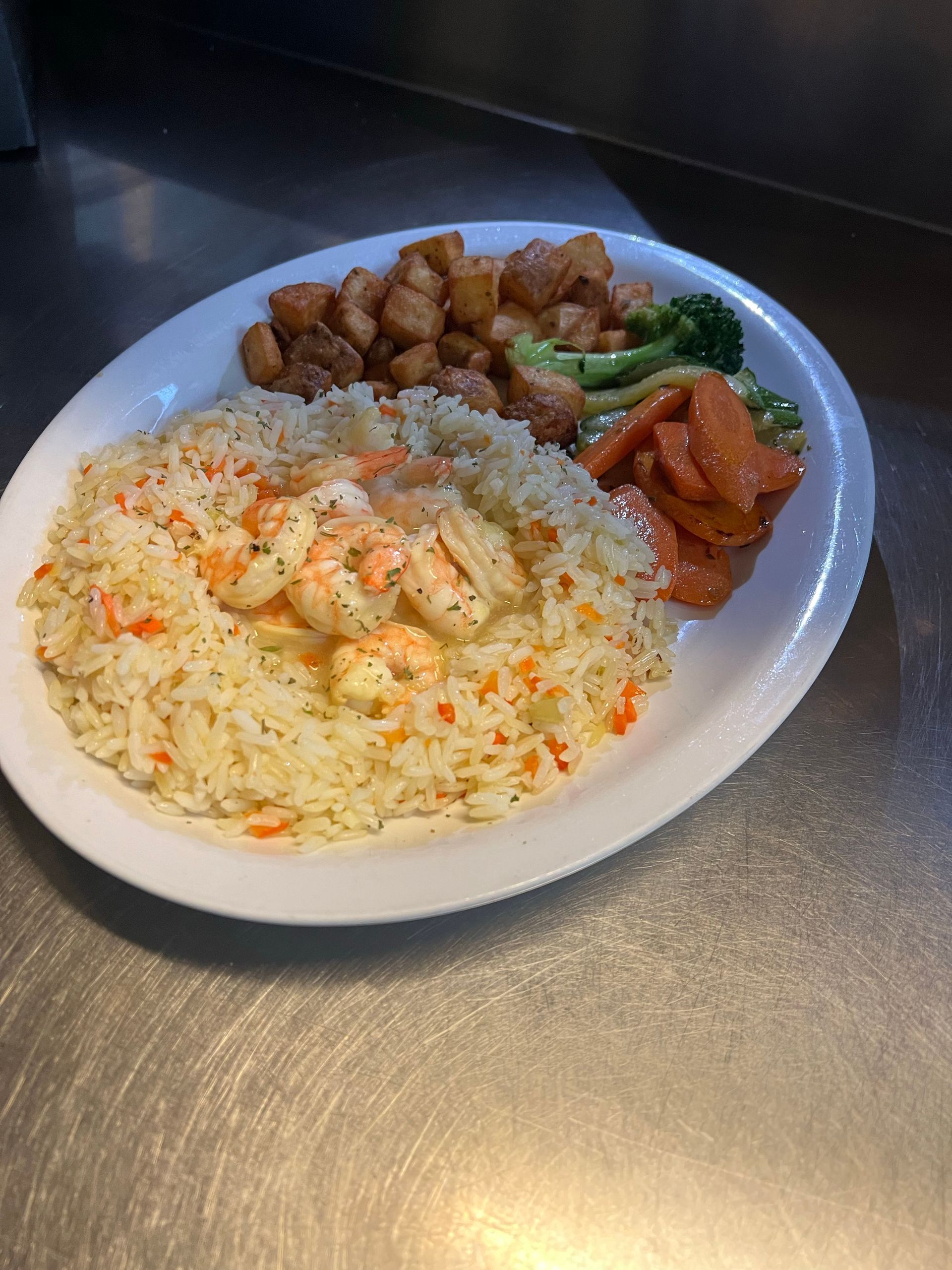 Plate of food with shrimp rice, fried chicken, broccoli, and carrots.