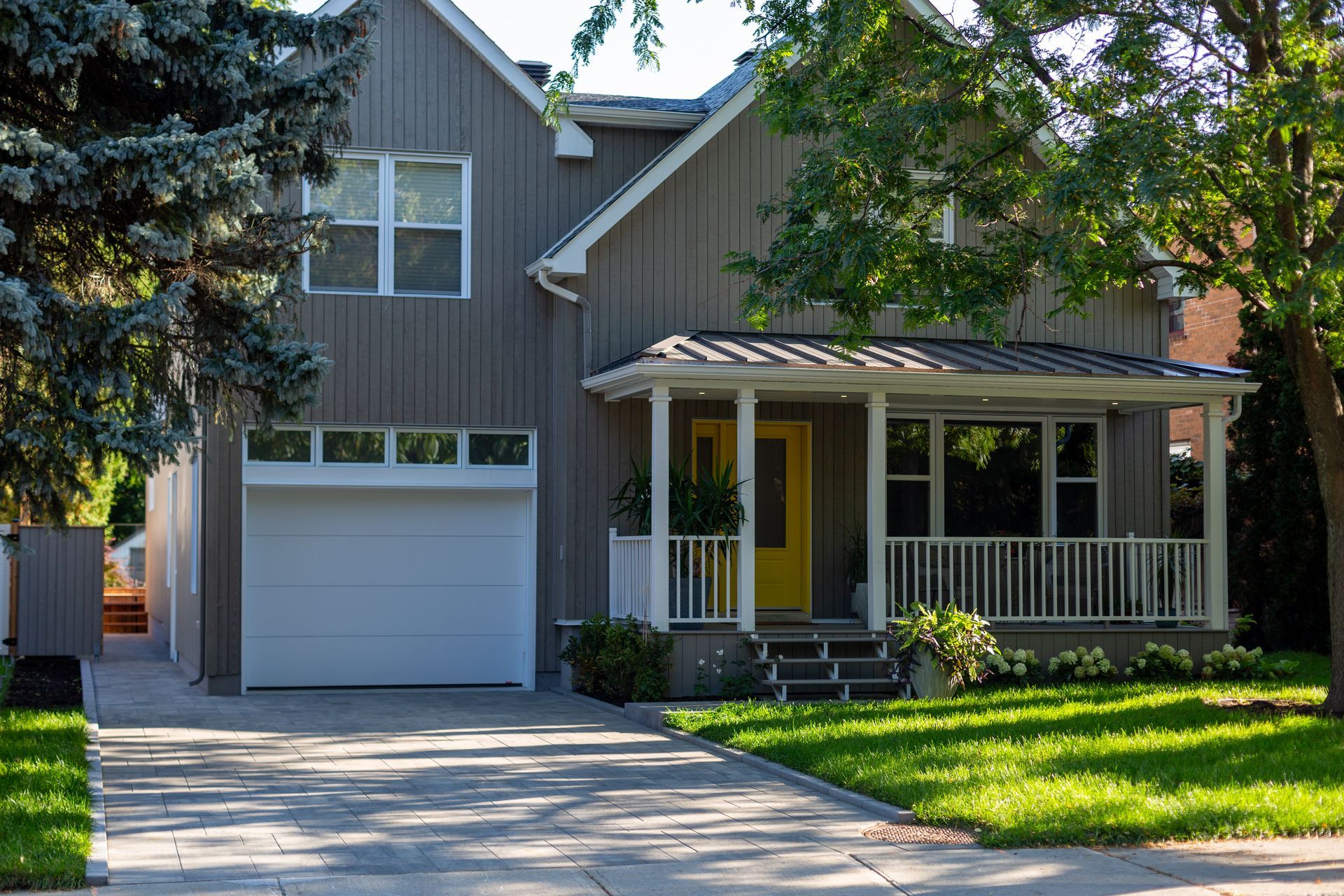 Une maison avec une porte jaune et une porte de garage blanche.