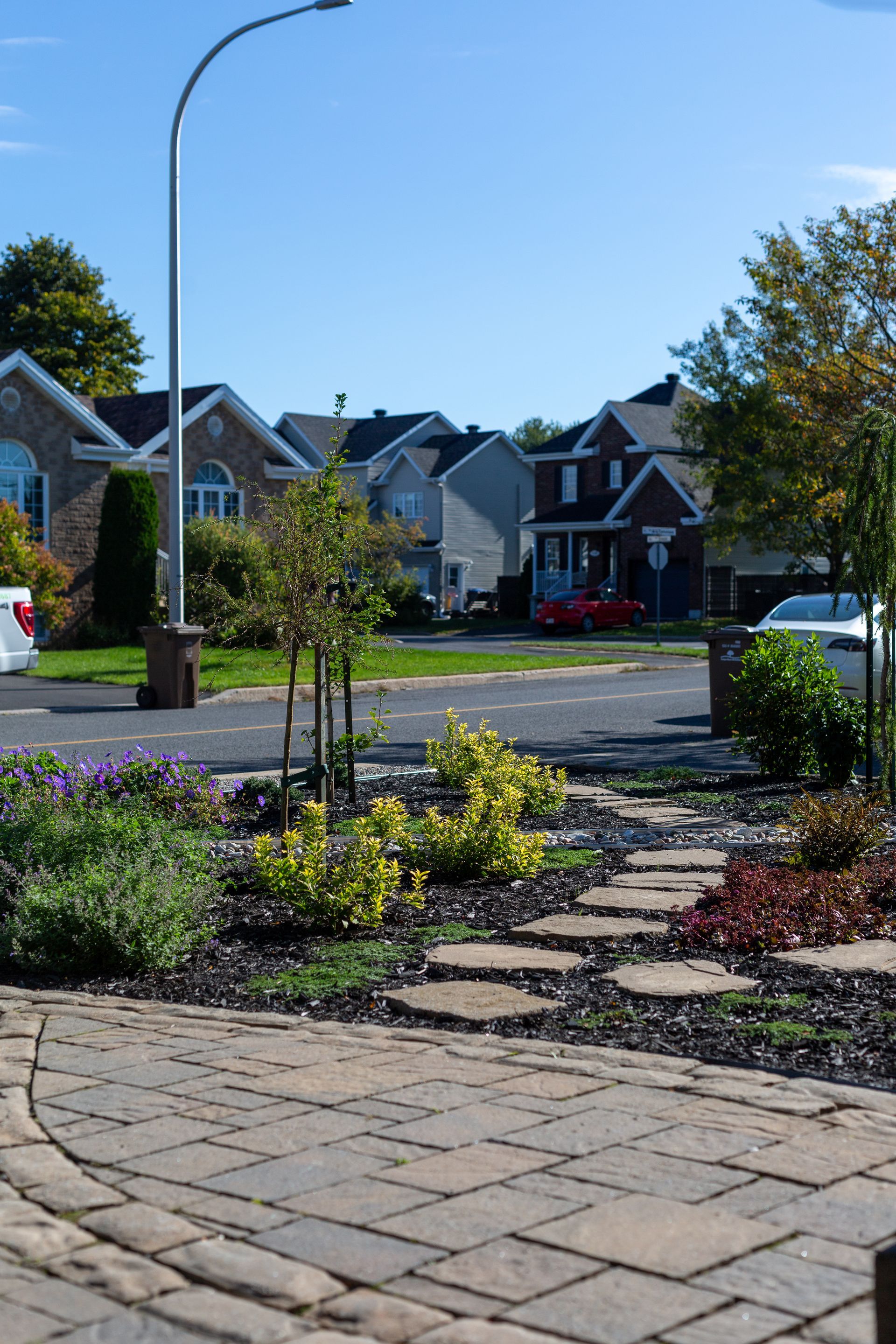 Une allée en briques menant à une rue avec des maisons en arrière-plan