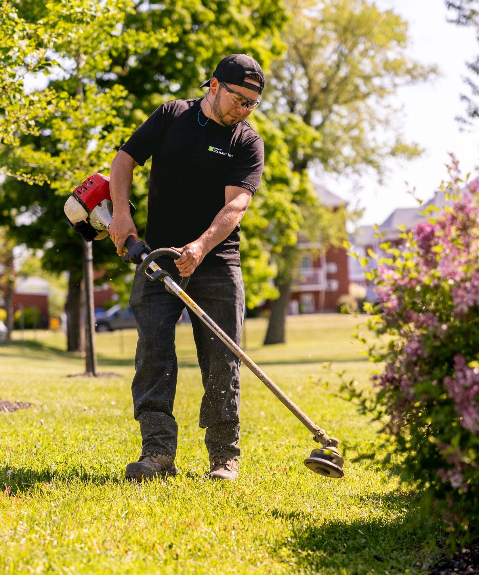 Un homme utilise une tondeuse à gazon pour couper l'herbe dans un parc.
