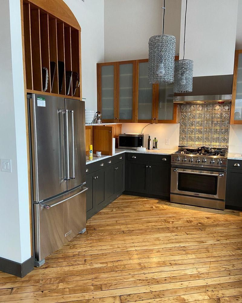 A kitchen with stainless steel appliances and wooden floors