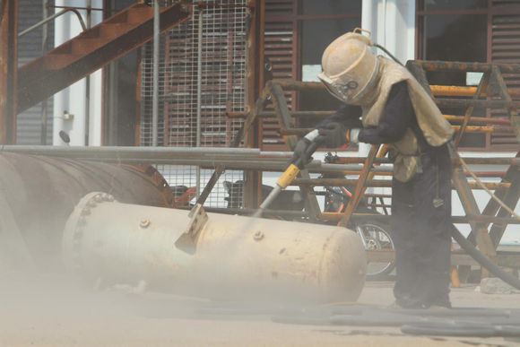 sandblaster cleaning the metal