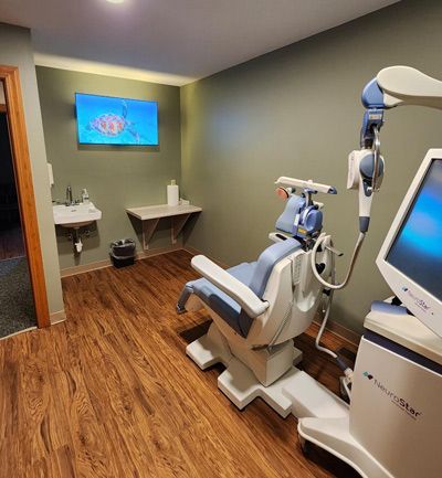 A room with a chair and a monitor in it