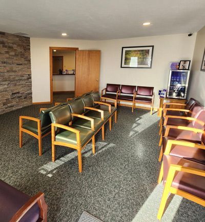 A waiting room with a lot of chairs and a picture on the wall