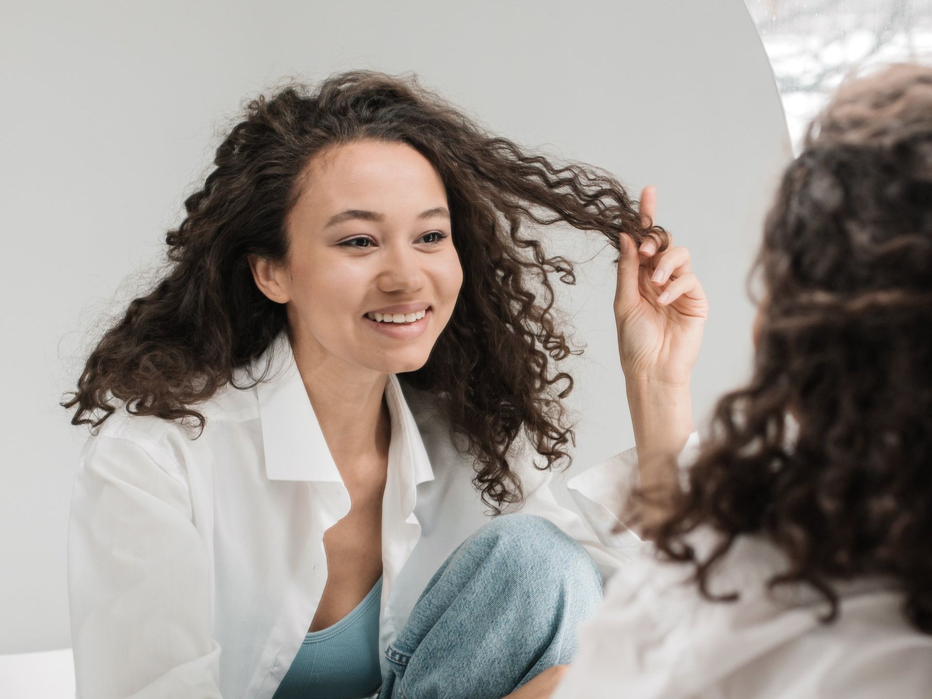 happy young woman looking in the mirror able to recognize her true self