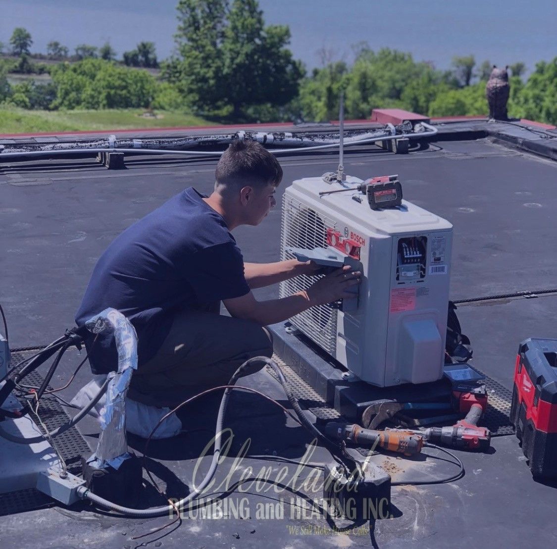 HVAC technician working on rooftop air conditioning unit. Sunny day.