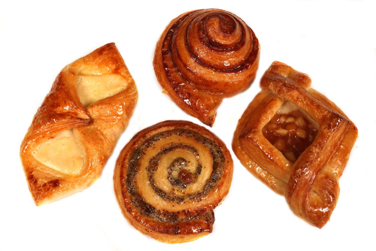 Pastries on a white surface, including spirals and folded shapes, glazed and golden-brown.