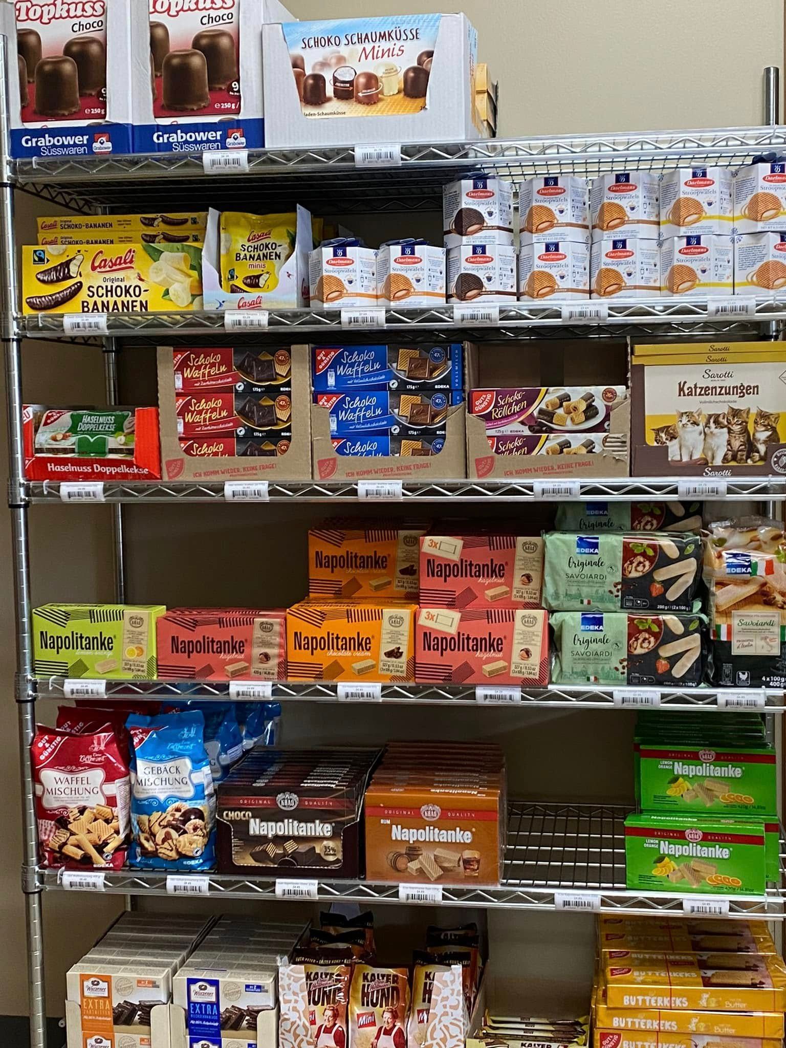 Shelves stocked with various packaged snacks, mostly cookies and chocolate, in a store setting.
