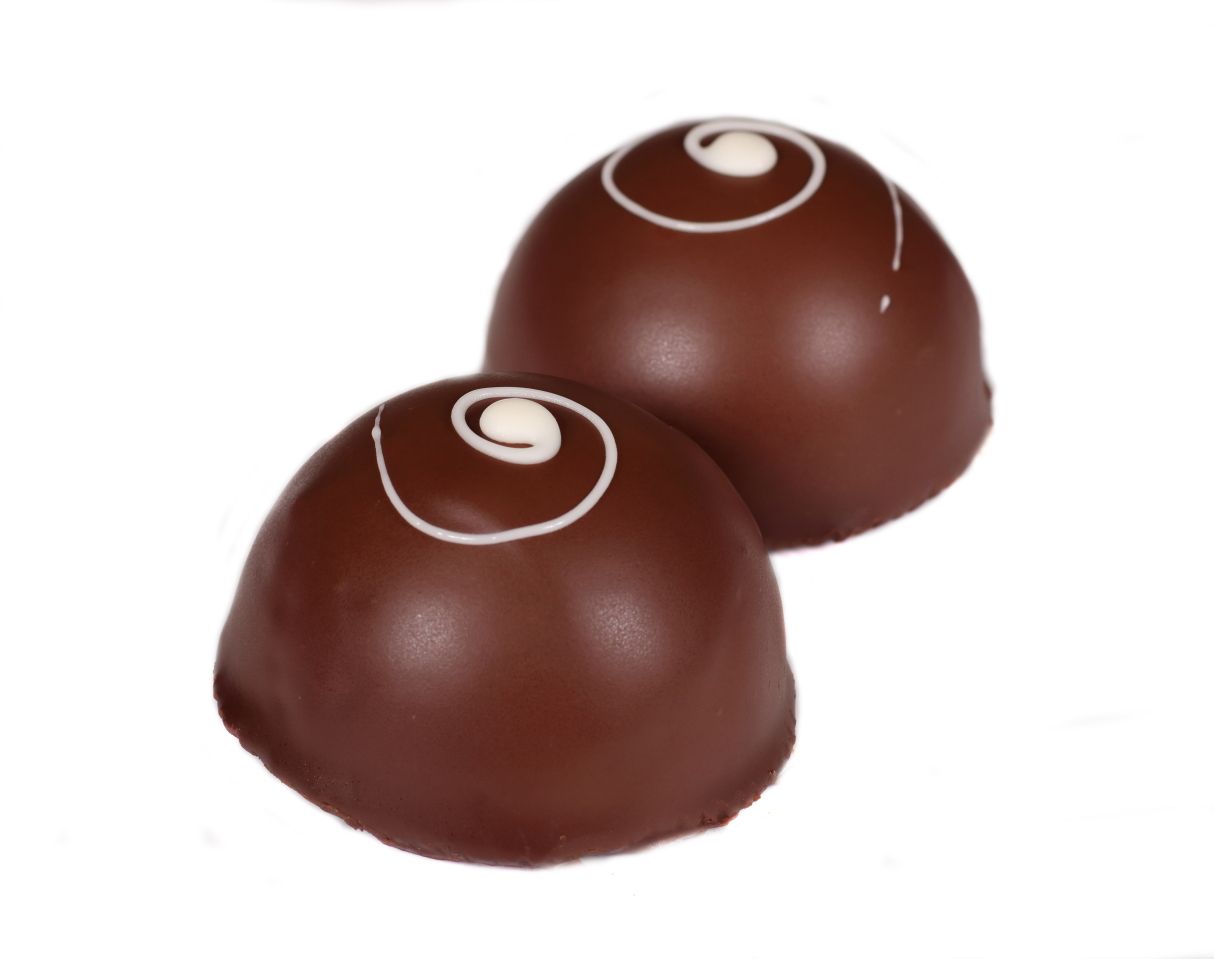 Two chocolate truffles, dome-shaped, with white swirl designs on top.
