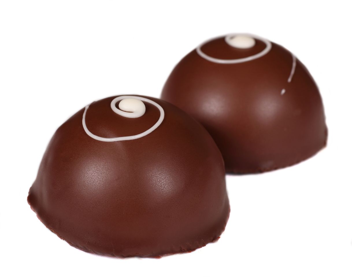 Two chocolate truffles with white spiral designs on top.