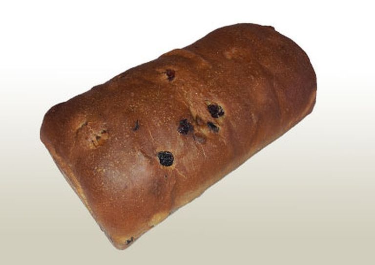 Loaf of golden-brown raisin bread, slightly oblong in shape, on a light gradient background.
