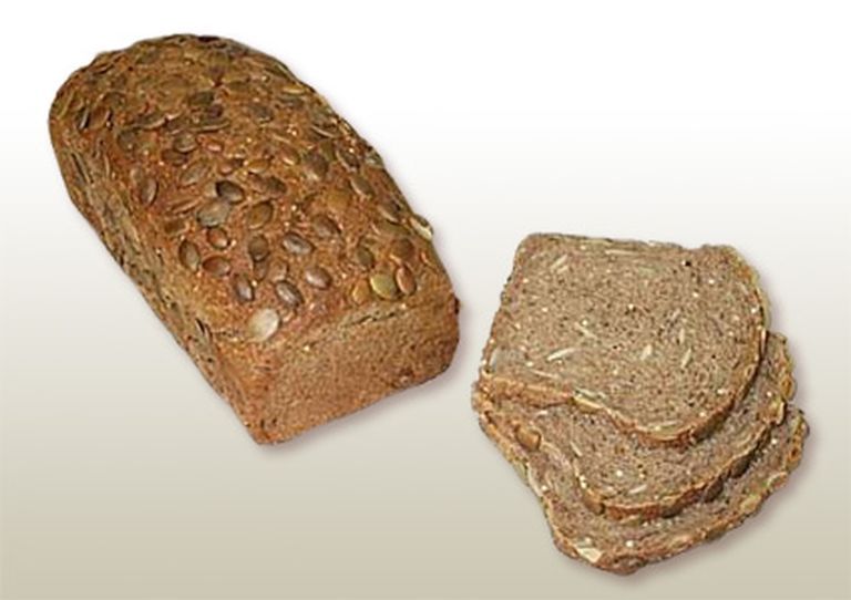 Loaf of golden-brown raisin bread, slightly oblong in shape, on a light gradient background.