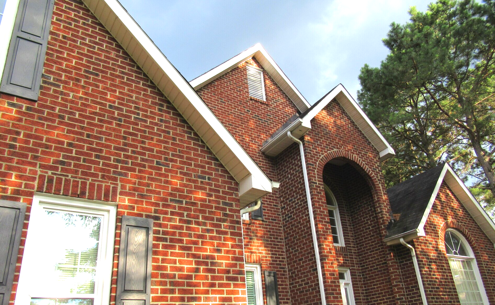 Close-up of a brick home showcasing newly installed gutters and white fascia boards, completed by Roof Dawgs.