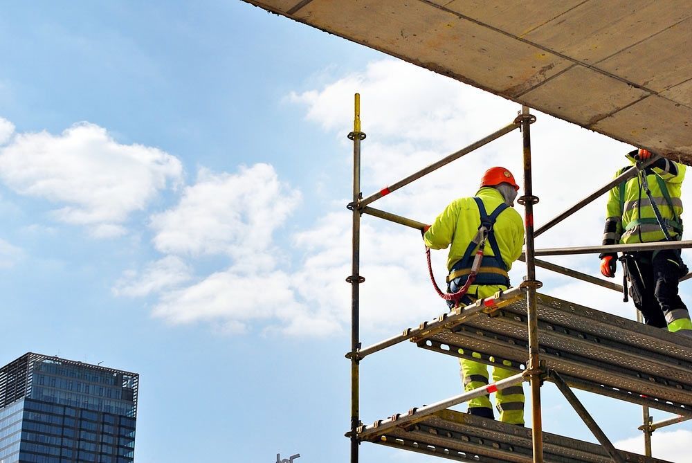 Two Construction Workers Are Standing On Top Of A Scaffolding — Triple S Scaffolding In Port Macquarie, NSW