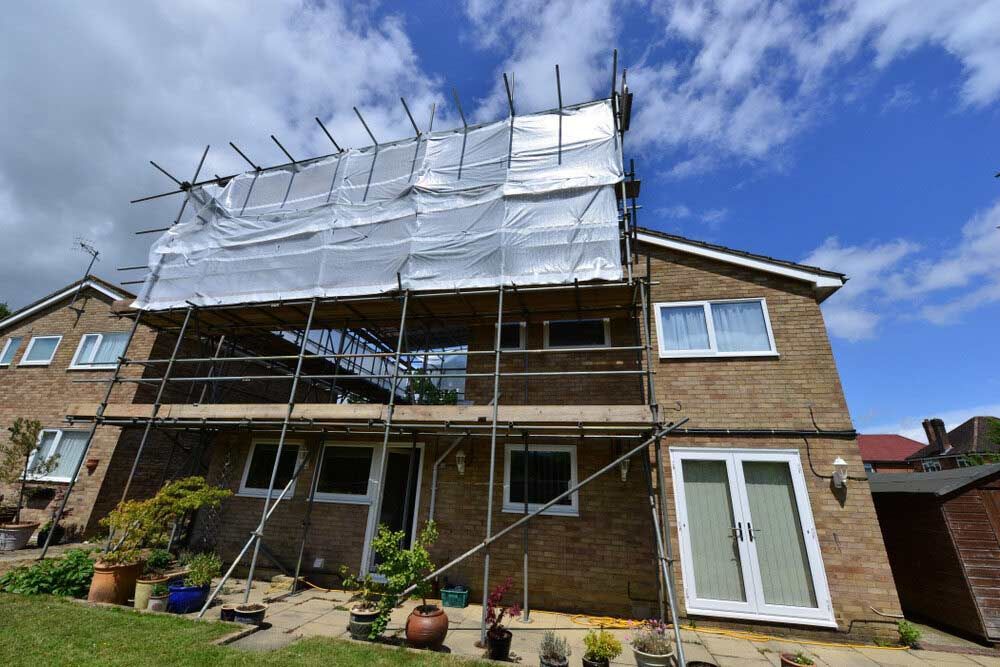 A Large Brick House With Scaffolding On The Side Of It — Triple S Scaffolding In Port Macquarie, NSW