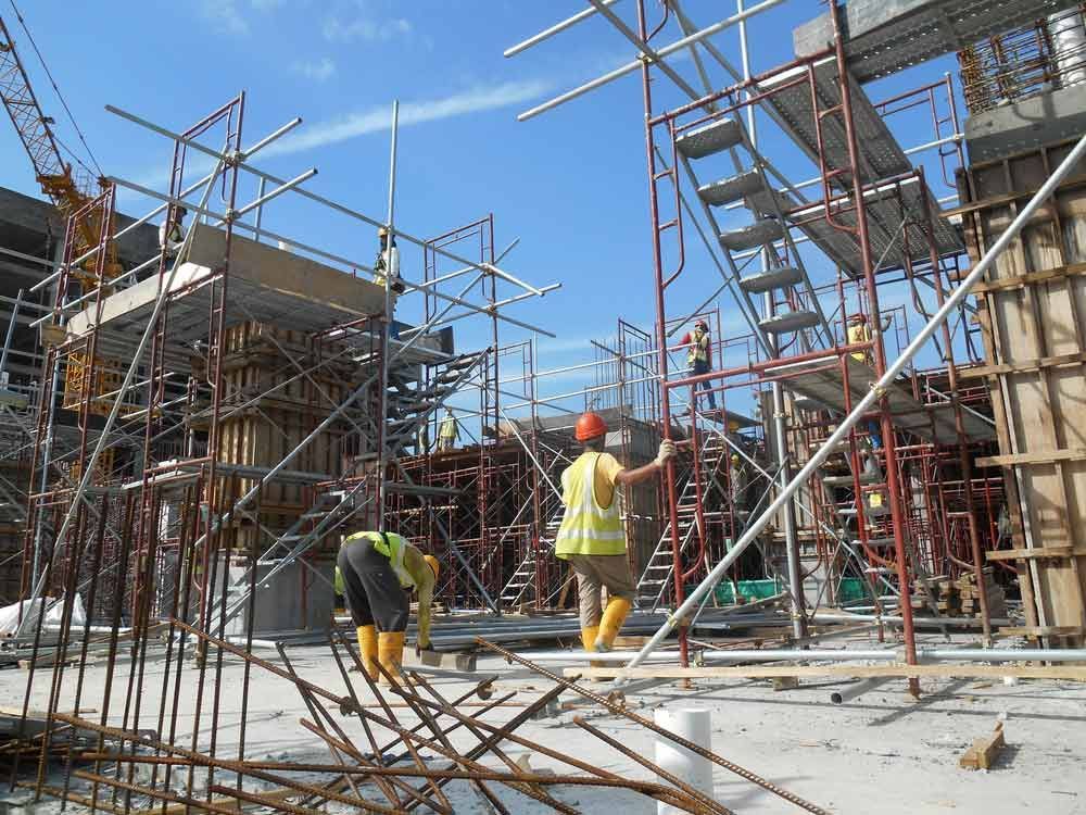 A Group Of Construction Workers Are Working On A Building Under Construction — Triple S Scaffolding In Port Macquarie, NSW