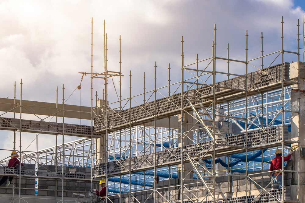A Large Building Is Being Built With Scaffolding Around It — Triple S Scaffolding In Wauchope, NSW