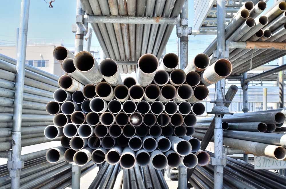 A Bunch Of Metal Pipes Are Stacked On Top Of Each Other On A Shelf — Triple S Scaffolding In Port Macquarie, NSW
