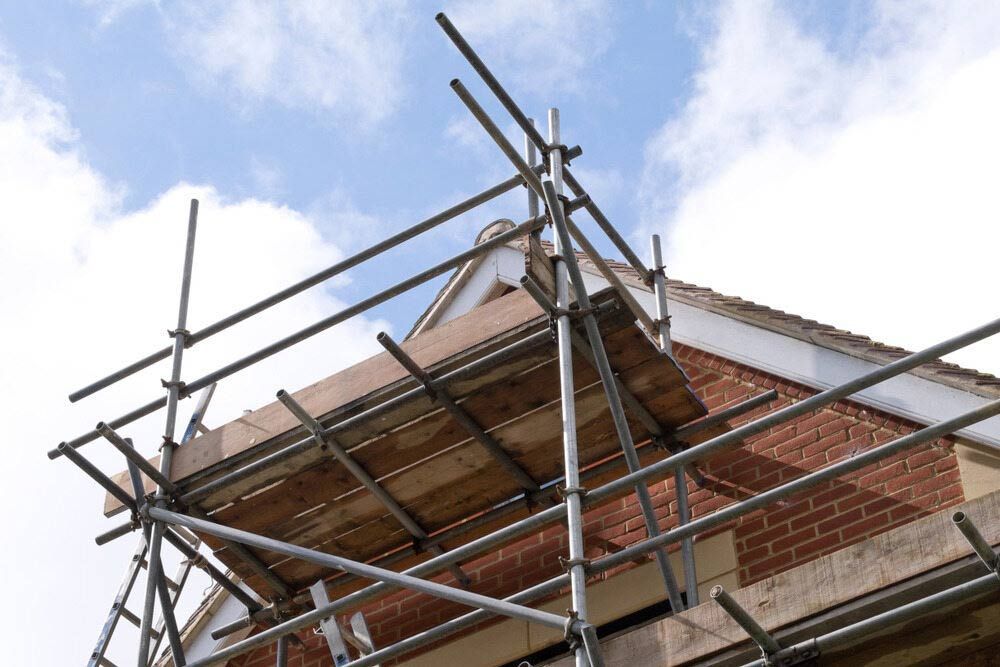 A Scaffolding Is Sitting On Top Of A Brick Building — Triple S Scaffolding In Kempsey, NSW