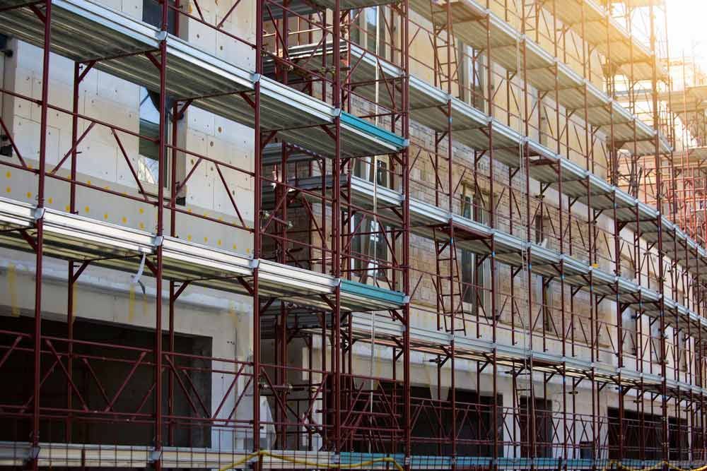 A Large Building Is Being Built With Scaffolding Around It — Triple S Scaffolding In Kempsey, NSW