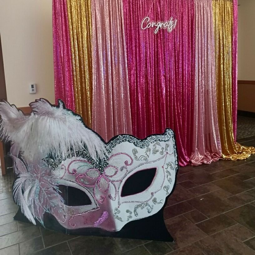 Masked party scene with a pink and gold sequin backdrop, and a 