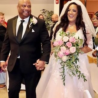 Bride and groom holding hands and smiling, walking down the aisle after their wedding.