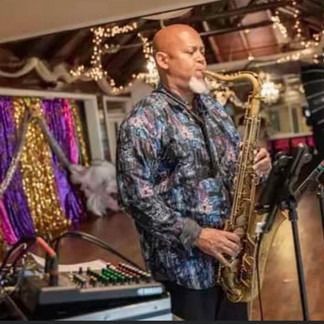 Man playing saxophone on stage with lights and decorations.