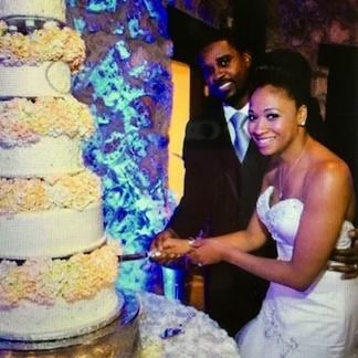 Bride and groom cutting wedding cake at reception.