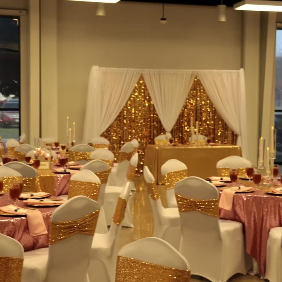 Banquet hall decorated in gold and blush for a wedding or celebration. Tables and chairs set for dining.