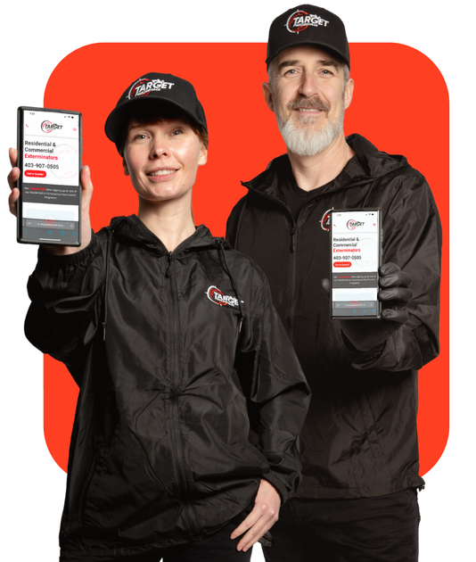 A man and a woman pest control technicians who are holding up their cell phones