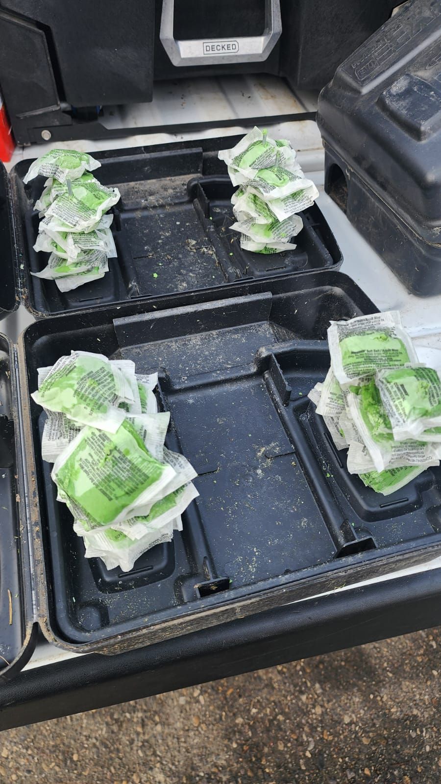 A bunch of green packets are sitting on top of a black tray.