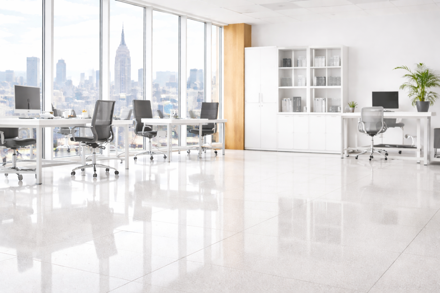 Bright, modern office space with white desks, chairs, and cabinets. Large windows offer city view, reflective flooring.