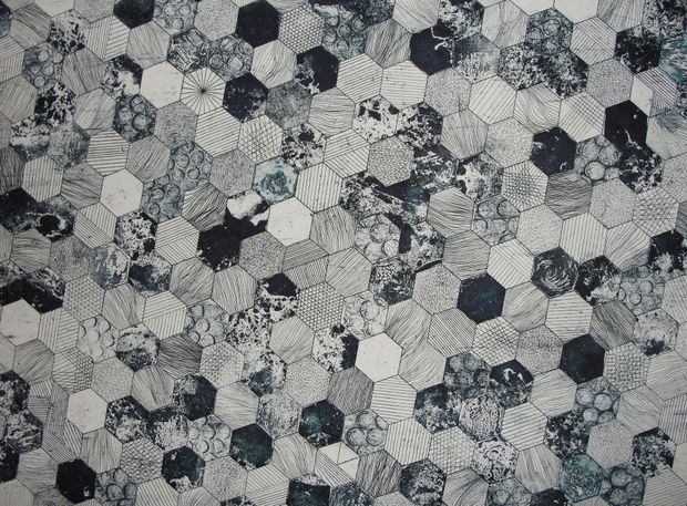 Honeycomb pattern textile in shades of gray and blue, with variations in texture and color within the hexagonal shapes.
