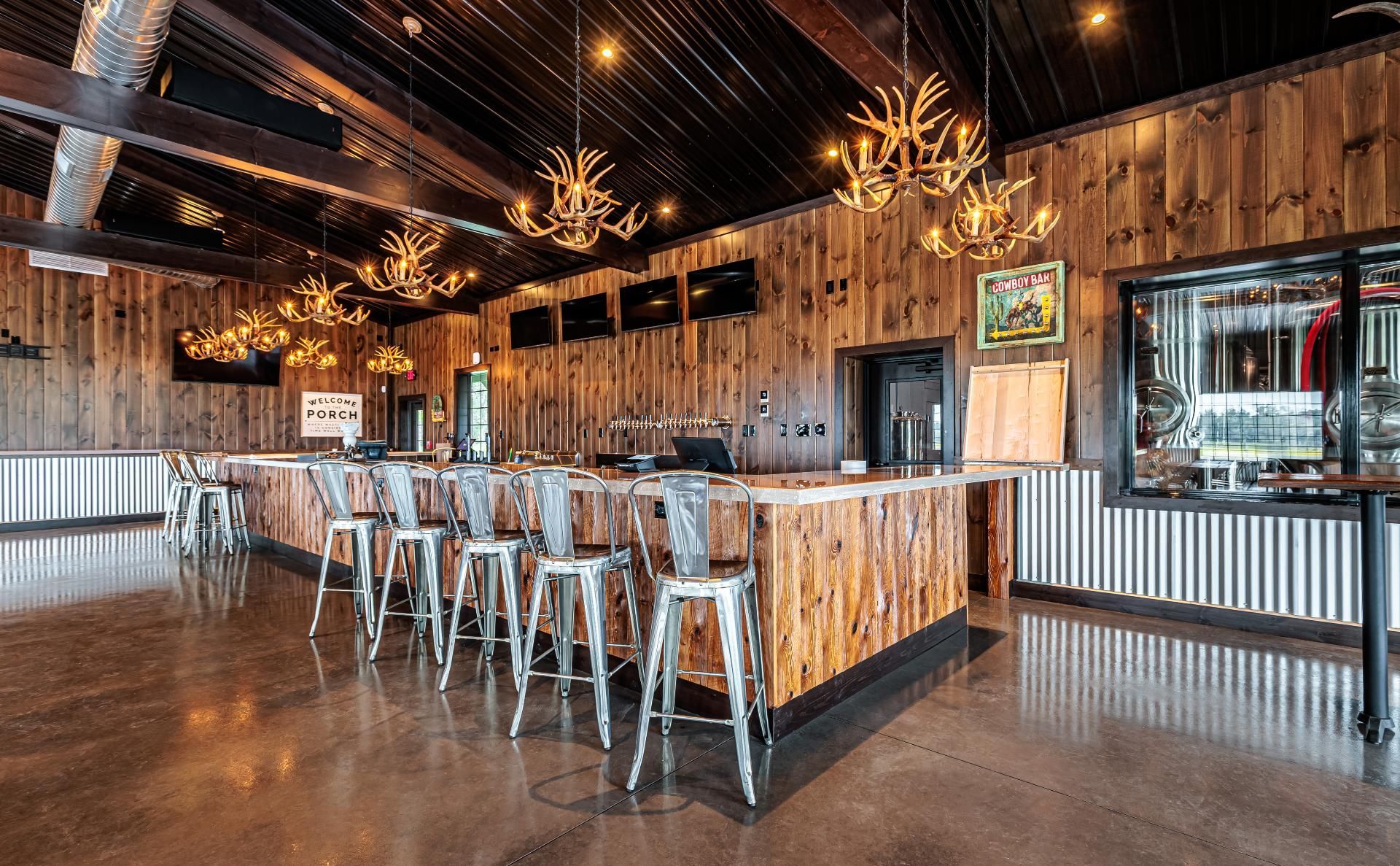 Interior shot of the Bullhide Brewery bar, with brewery equipment viewable through an interior window 