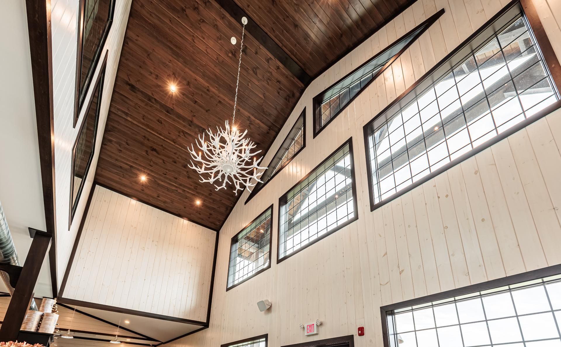 Interior shot of Bullhide Brewery showing the high ceiling directly inside the entryway, with a white antler chandelier
  