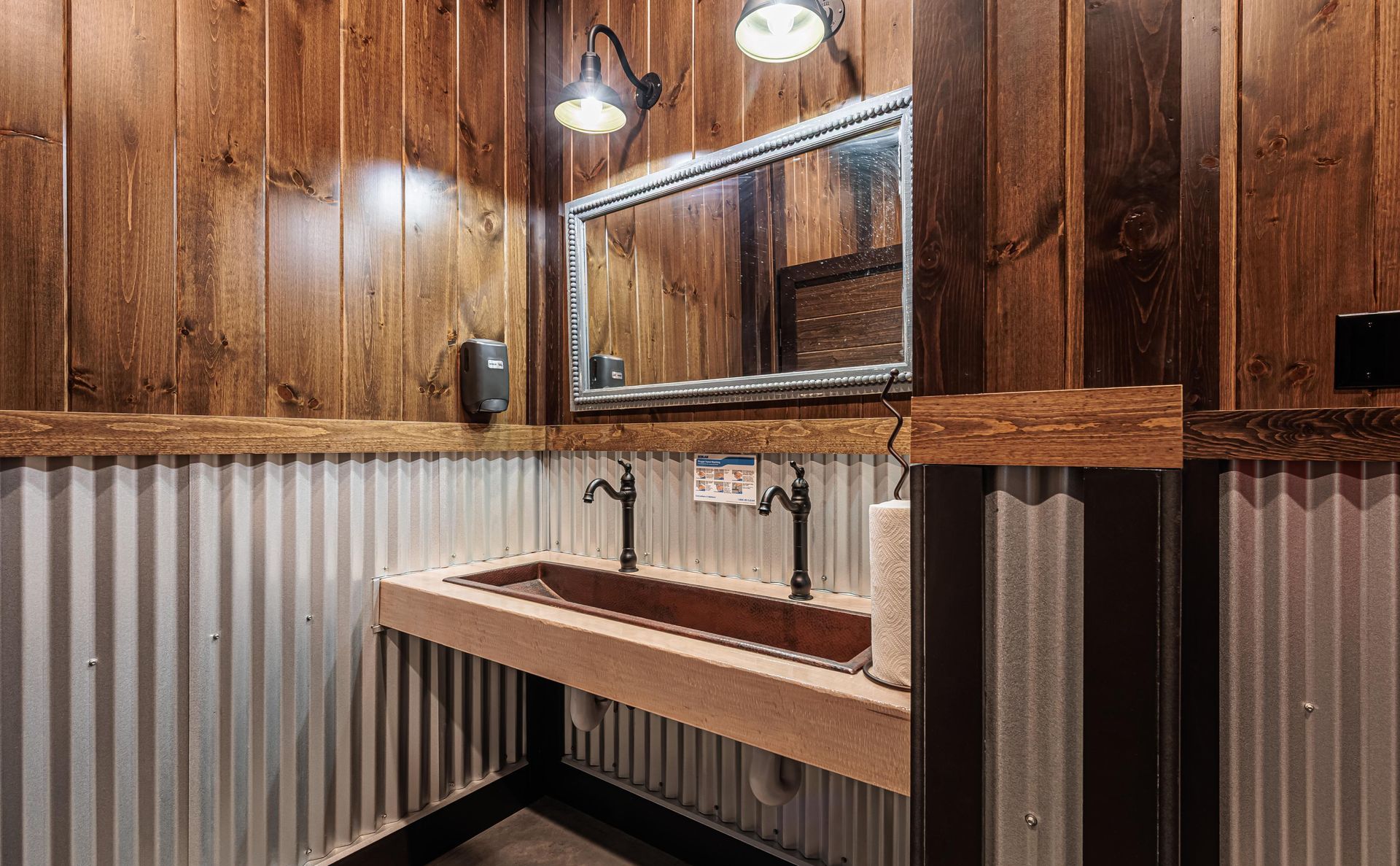 Interior shot of the newly constructed Bullhide Brewery restrooms showing the rustic industrial interior and double sink
