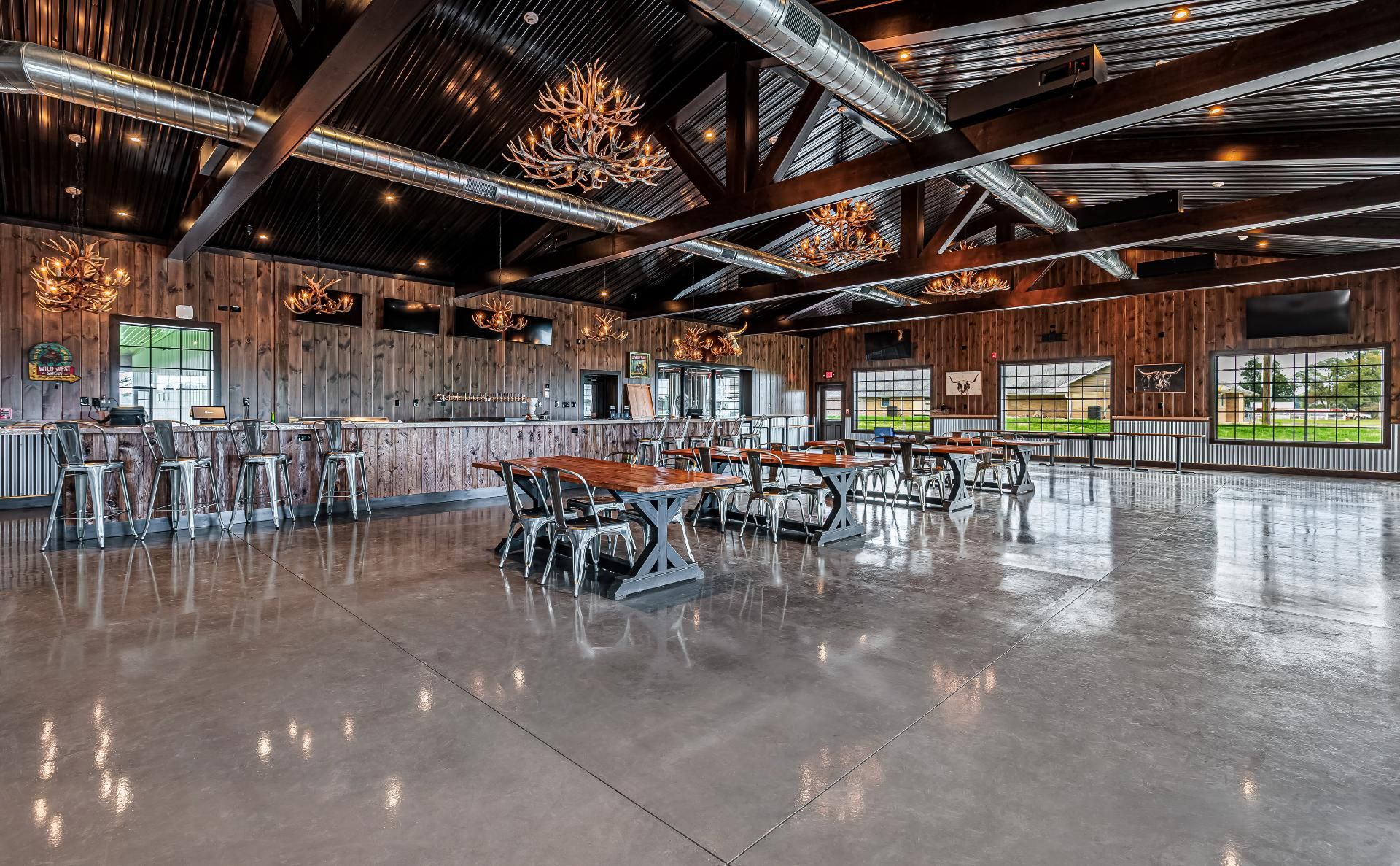 Interior of Bullhide Brewery seating area, highlighting the timber frame construction and rustic industrial interior with metal siding chair rail and wood plank interior wall covering