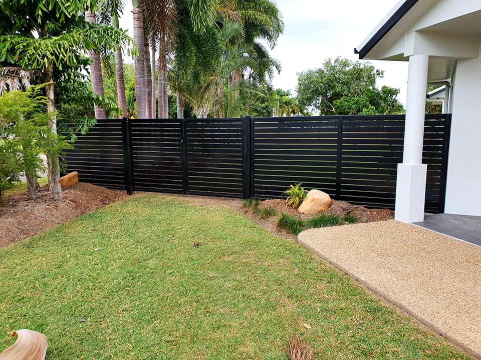 A Black Fence Surrounds a Lush Green Lawn in Front of a House — Gate-O-Matic In Kelso, QLD