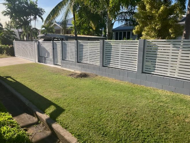 A White Fence Surrounds a Lush Green Lawn in Front of a House — Gate-O-Matic In Kelso, QLD