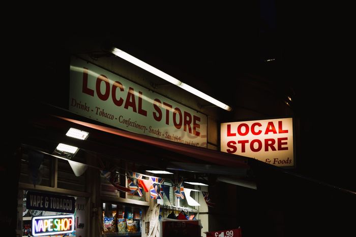 a store front at night with the words local store on the sign