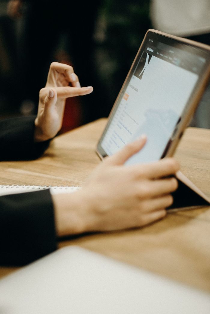 a persons hands tapping and ipad screen