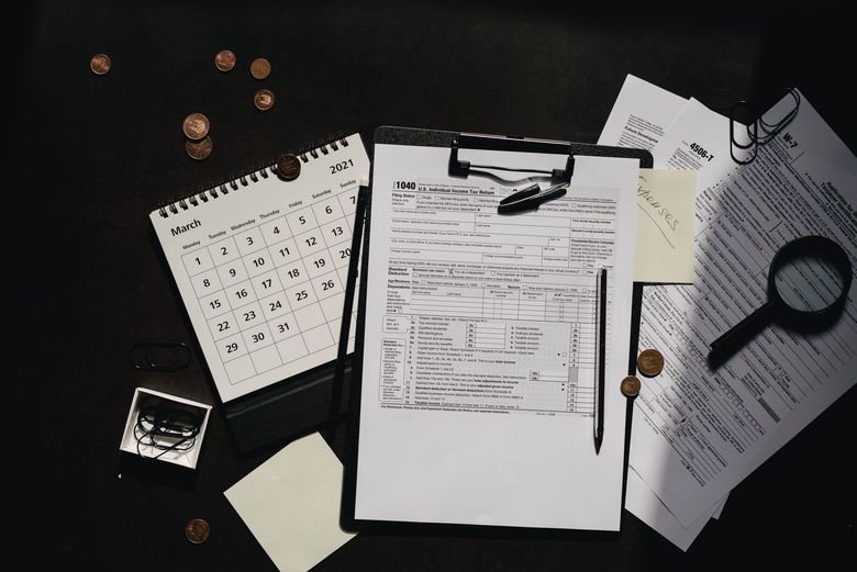 Clipboards, tax documents, and other papers depicting a messy desk