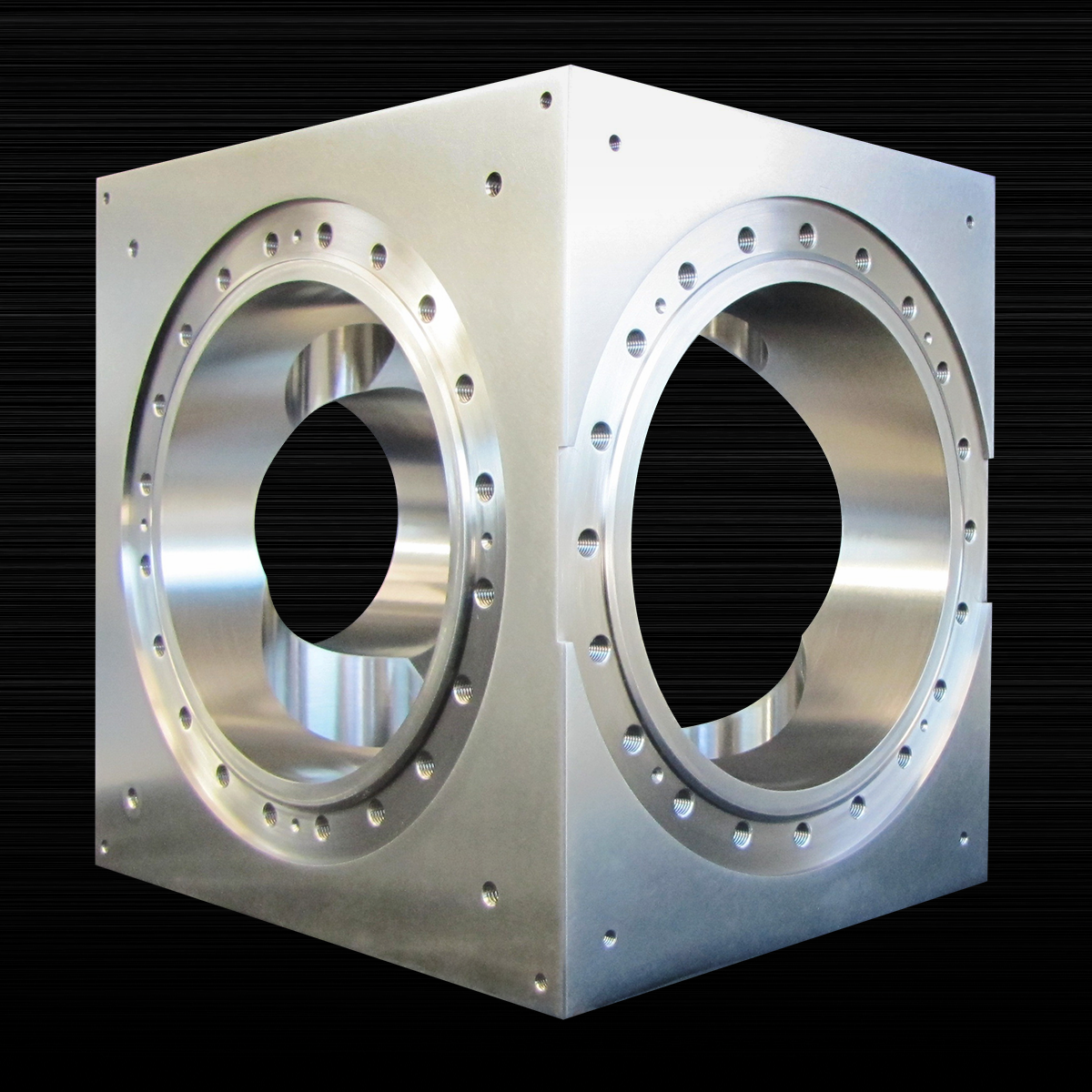 A metal cube with two holes in it