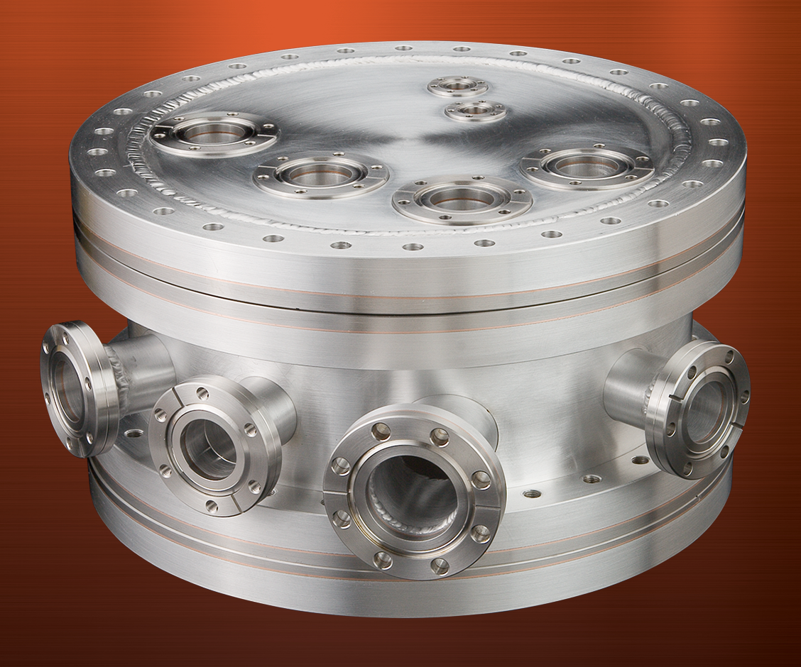 A cylindrical aluminum vacuum chamber with multiple bimetal aluminum/stainless flanges welded around the sides and on the top.