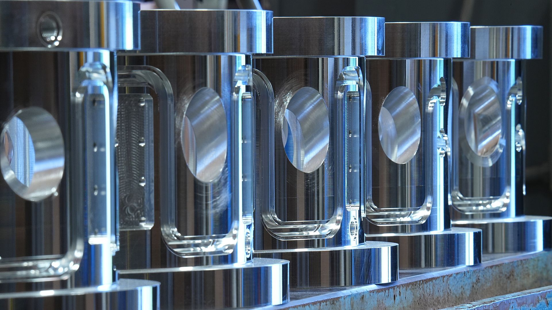 A row of aluminum cylinder shaped vacuum chambers with water channels.