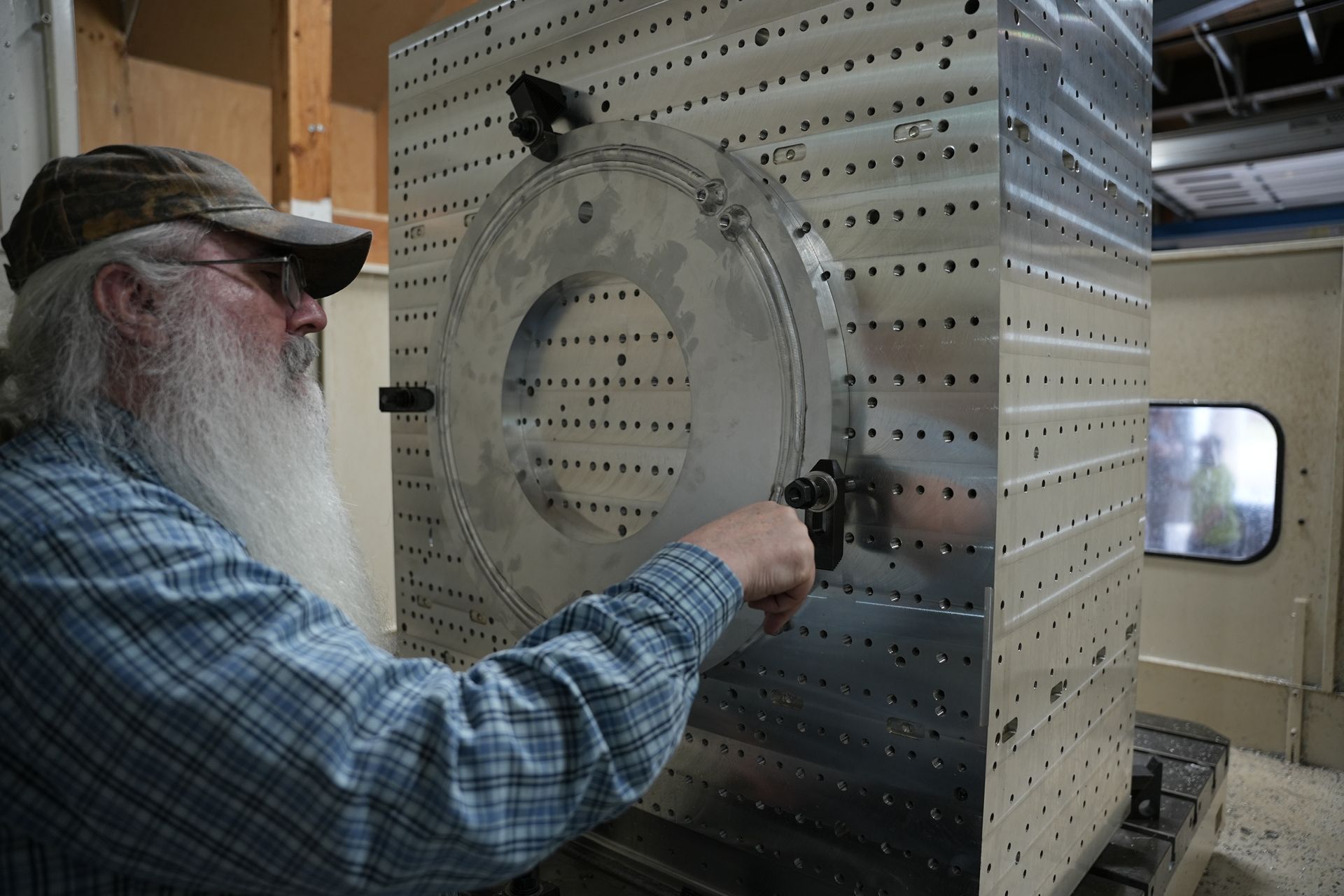 A man with a beard is working on a machine.
