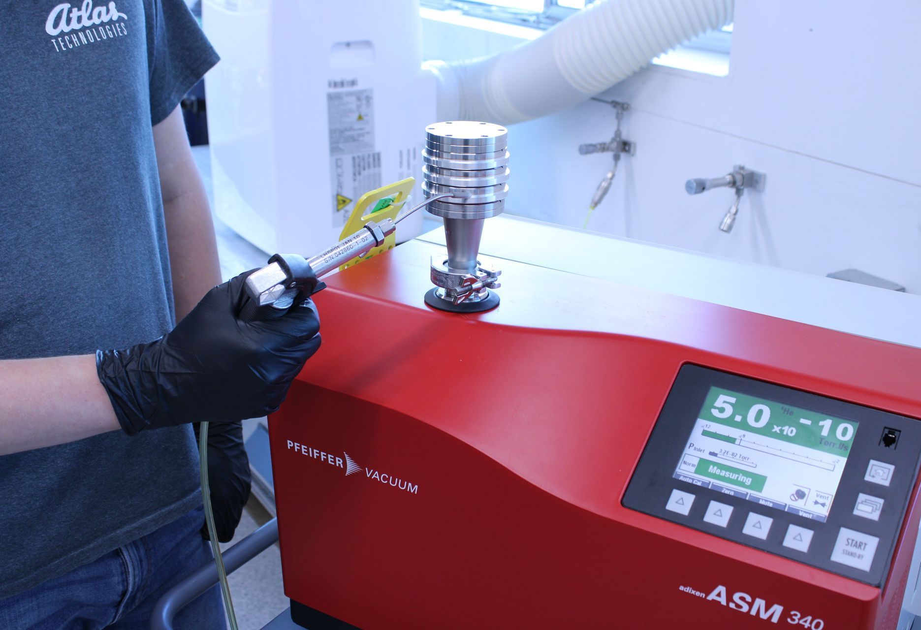 A man wearing black gloves is using a red asm 340 machine