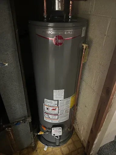 Gray Rheem Performance Plus water heater in a basement.