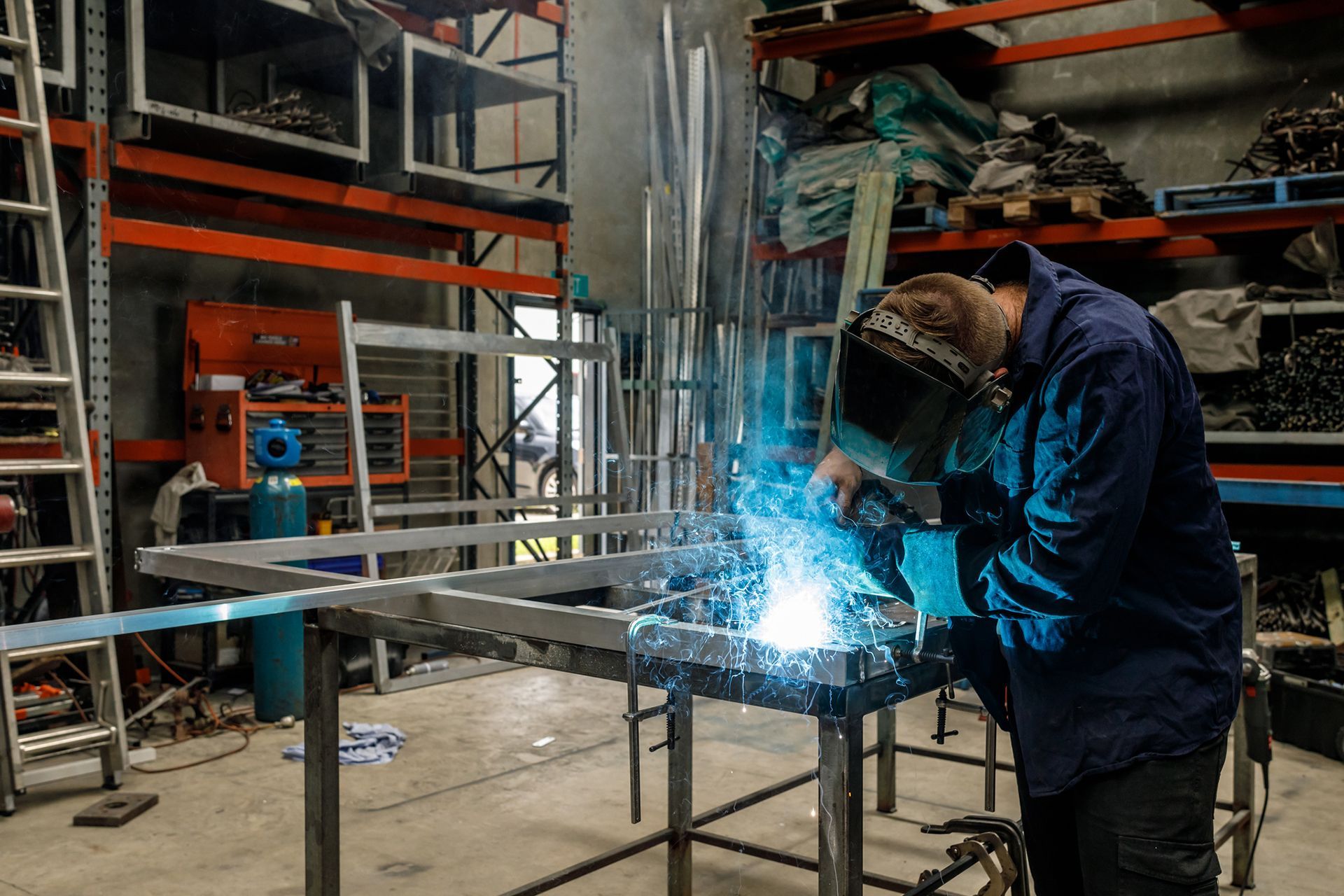 A young Australian apprentice metal worker welding in a factory. A young Australian apprentice metal worker welding in a factory.